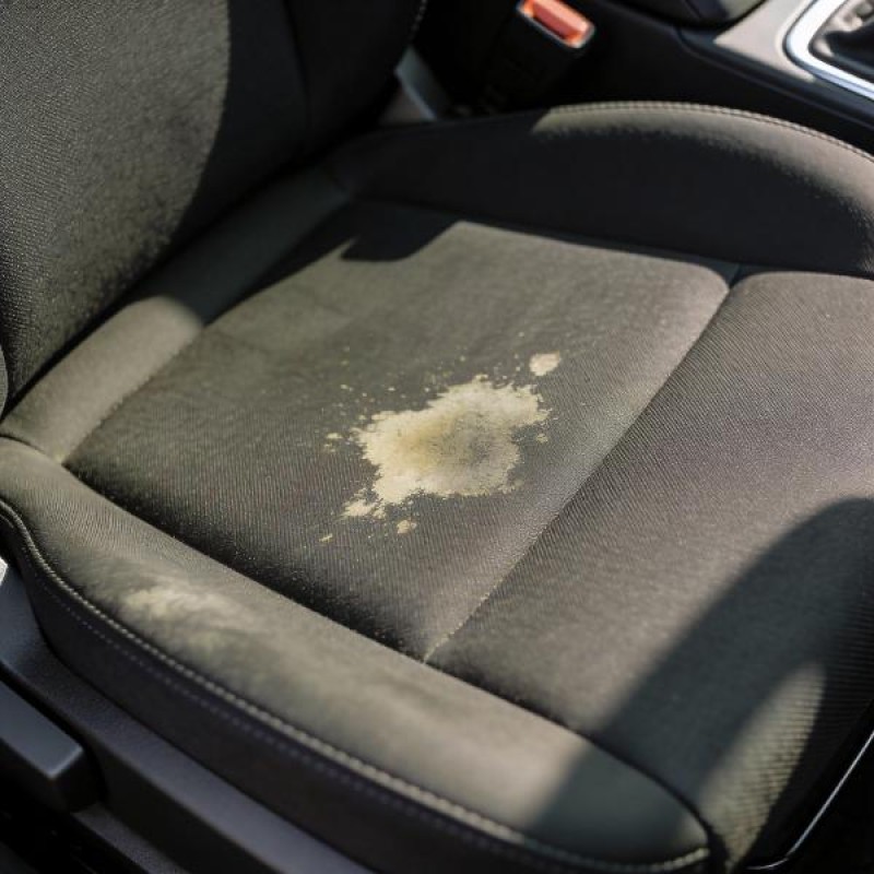 Dirty stained car seat upholstery before professional same day auto interior deep cleaning and stain removal